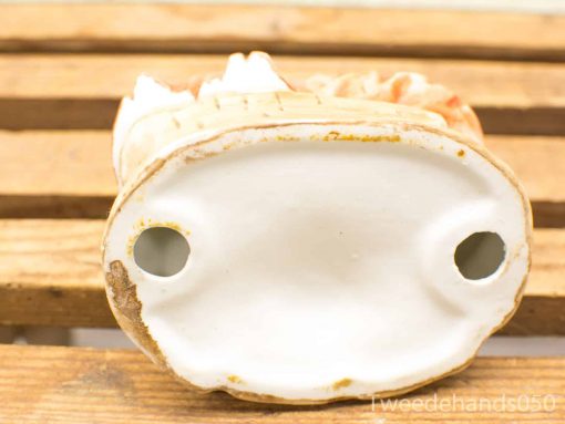 Antique ceramic figurine in earthy tones, showcasing vintage charm and exquisite craftsmanship.