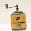 Vintage Henbrouck coffee grinder in pastel colors, showcasing charm and craftsmanship with a worn finish.