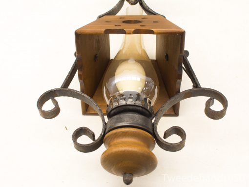 Rustic wall lamp with wood and metal design, featuring a charming exposed bulb for cozy ambiance.