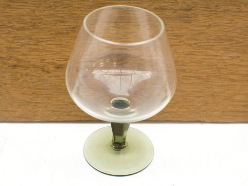 Elegant crystal brandy glass with unique green base, perfect for fine spirits and special occasions.