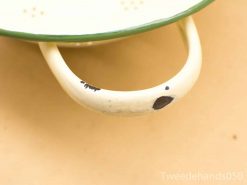 Vintage green-rimmed metal colander, perfect for draining pasta with nostalgic charm.