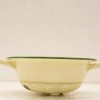 Vintage yellow enamel colander with green trim, perfect for draining pasta and vegetables.