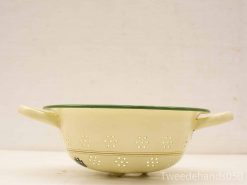 Vintage yellow enamel colander with green trim, perfect for draining pasta and vegetables.