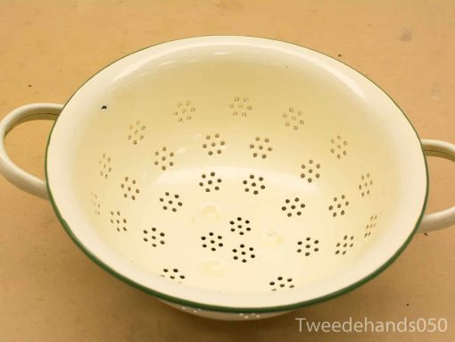 Vintage yellow enamel colander with floral pattern and green rim, perfect for kitchen use.