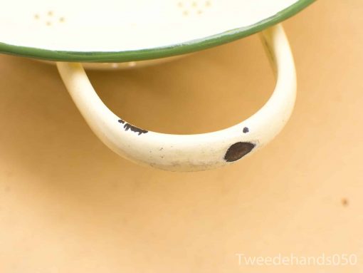 Vintage green-rimmed metal colander, perfect for draining pasta with nostalgic charm.
