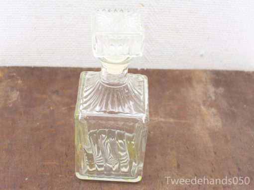Elegant vintage glass decanter with ornate stopper, perfect for spirits or decorative display.