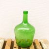 Elegant vintage green glass bottle on rustic wooden surface, showcasing charm and history.