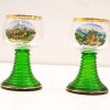 Vintage decorative glasses featuring scenic landscapes and gilded rims, perfect for collectors.