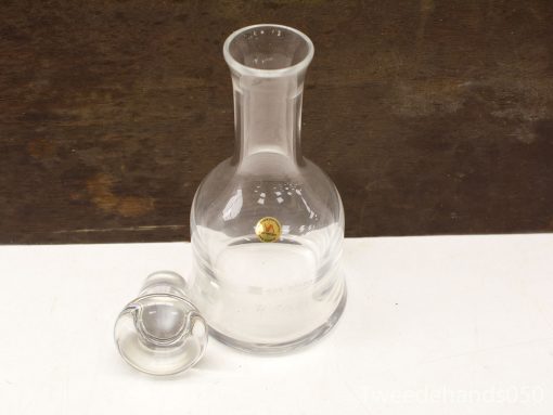 Elegant glass decanter with star seal and stopper, perfect for fine dining and decoration.