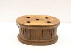 Rustic vintage wooden container with holes and metal band, perfect for decor and storage.