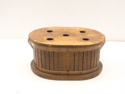 Rustic vintage wooden container with holes and metal band, perfect for decor and storage.