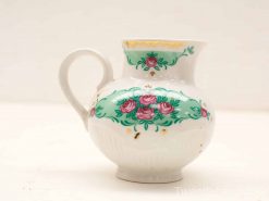 Elegant ceramic jug with floral motifs and golden accents, perfect for decor or serving.