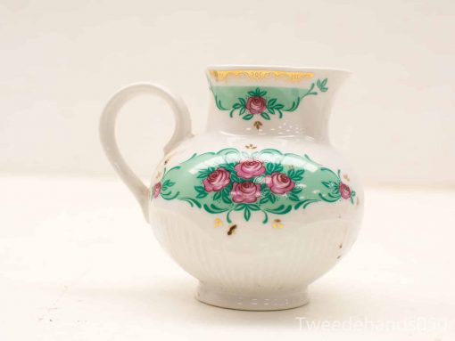 Elegant ceramic jug with floral motifs and golden accents, perfect for decor or serving.