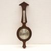 Vintage wooden barometer with thermometer, elegant design for weather forecasting and decoration.
