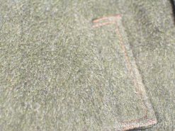 Soft green wool fabric with orange stitching, perfect for cozy, rustic fashion accessories.