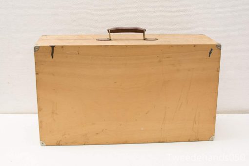 Vintage wooden suitcase with history, leather handle, and metal corner protectors.