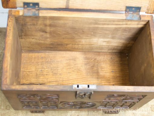 Antique wooden chest with intricate carvings and a warm, inviting interior. Perfect for storage.