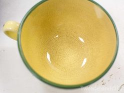 Vibrant yellow ceramic cup with crackle pattern and elegant green rim, perfect for unique decor.