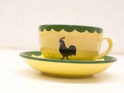 Charming yellow vintage teacup and saucer with rooster design, perfect for tea or decoration.