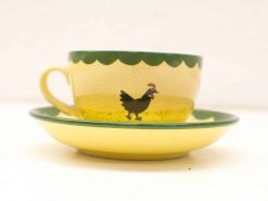 Charming vintage yellow tea cup and saucer with whimsical chicken design, perfect for cozy moments.