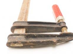 Heavy-duty vintage C-clamp with red handle, ideal for woodworking and metalworking projects.