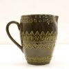 Handcrafted dark green ceramic jug with intricate triangular and diamond patterns for home decor.
