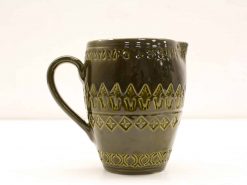 Handcrafted dark green ceramic jug with intricate triangular and diamond patterns for home decor.