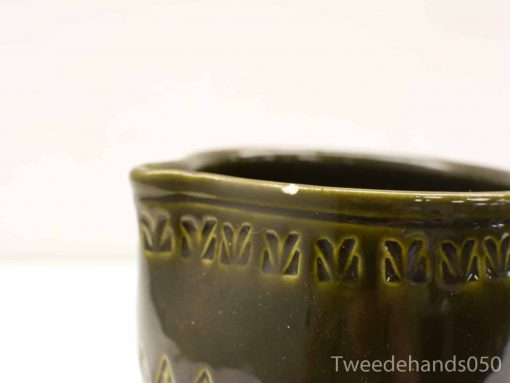 Handmade glossy green ceramic pot with decorative leaf details, ideal for plants or decor.