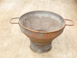 Rustic vintage metal colander with character, perfect for draining and kitchen decor.