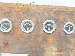 Vintage wooden control panel with gauges for pressure, fuel, temperature, and electrical current tracking.