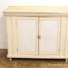 Charming vintage cream cabinet with two doors, metal trim, and rustic character for stylish storage.