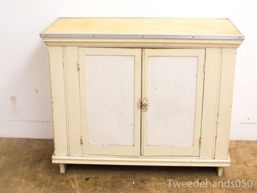 Charming vintage cream cabinet with two doors, metal trim, and rustic character for stylish storage.