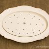 Elegant vintage oval ceramic serving platter with scalloped edges and functional drainage holes.
