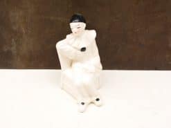 Vintage porcelain pierrot clown figurine with elegant pose and wistful expression, ideal for collectors.