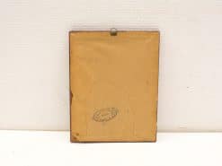Aged wooden frame back with vintage charm, featuring worn paper and hanging hook.