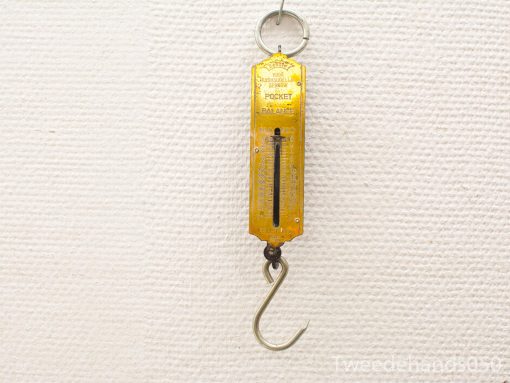 Vintage yellow pocket balance scale for precise weighing of small items.