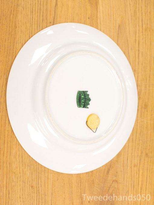 Elegant plate with whimsical crown design and cracker on rustic wooden table.