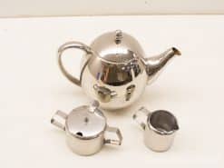 Elegant stainless steel teapot set with sugar bowl and cream jug for stylish tea service.