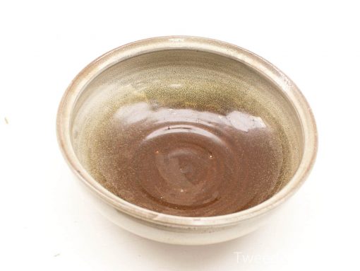 Handcrafted glossy ceramic bowl in earthy tones, featuring a spiral design and warm, inviting interior.
