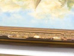 Antique gilded frame surrounding a serene landscape painting with delicate colors and charm.