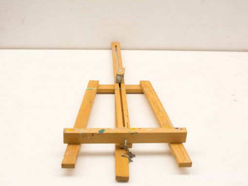 Vintage wooden easel with colorful paint splatters, ideal for artists and creative projects.
