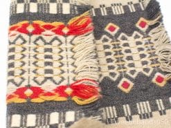 Vibrant vintage woven tablecloth with fringes, featuring rich colors and intricate geometric patterns.