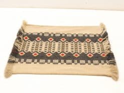 Handwoven vintage rug with diamond patterns in beige, gray, and red accents. Perfect decor piece.