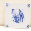 Vintage blue and white ceramic tile depicting an intimate conversation between a man and woman.