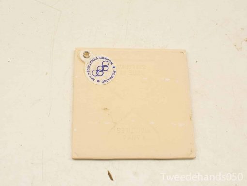 Cream-colored Olympic memorabilia with interlocking rings, ideal for collectors and sports enthusiasts.