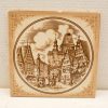 Charming ceramic plate featuring a vintage village scene with traditional houses and a clock tower.