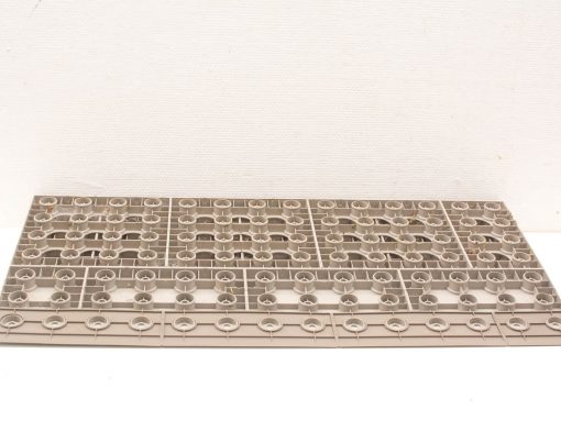 Rectangular plastic sheet with circular cutouts for efficient organization and storage of small items.