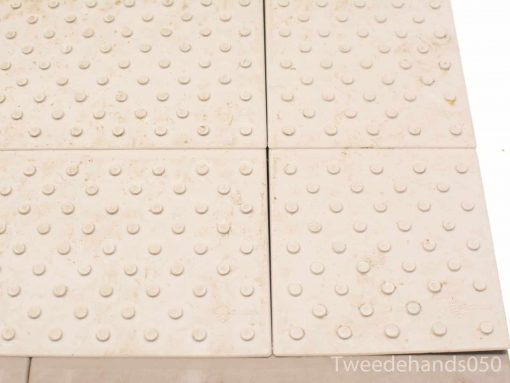 Gray textured tiles with bumps for safety and accessibility in public spaces.