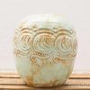 Handmade blue-green ceramic pot with intricate wave design, perfect for decor or plants.