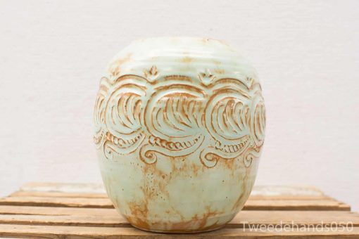 Handmade blue-green ceramic pot with intricate wave design, perfect for decor or plants.
